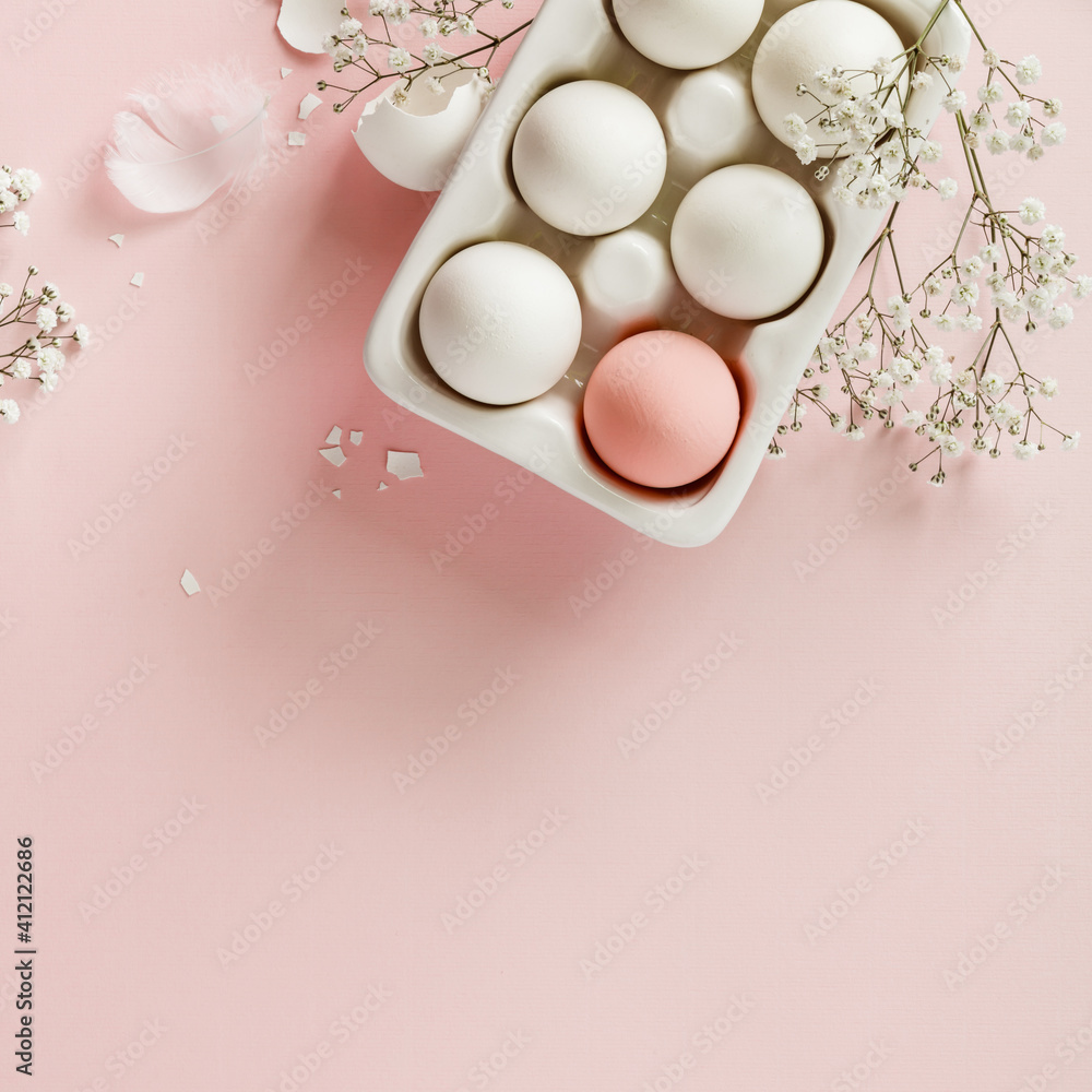 白色陶瓷托复活节彩蛋和粉色背景花朵