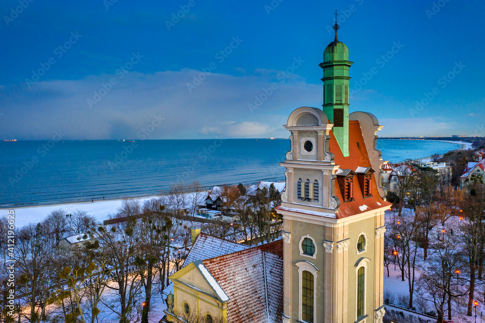 黄昏时分，波兰索波特波罗的海白雪皑皑的海边美丽的教堂