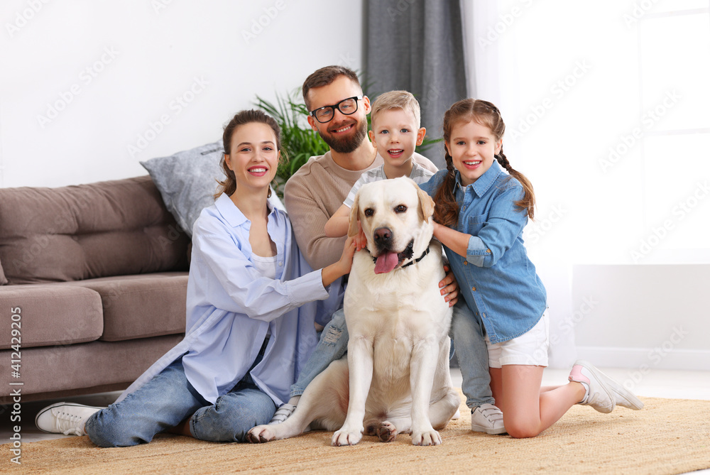 幸福的一家人在家和他们最喜欢的宠物狗玩耍