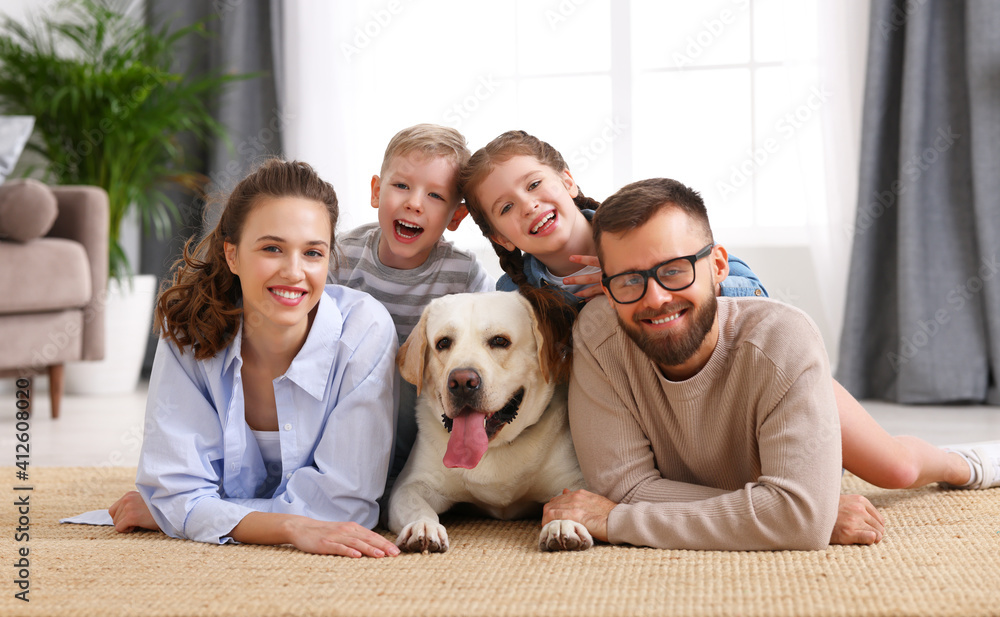 幸福的家庭在家里和他们最喜欢的宠物狗玩耍