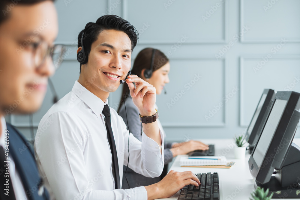 Asian call center team, customer service, telesales in formal suit wearing headset or headphone talk