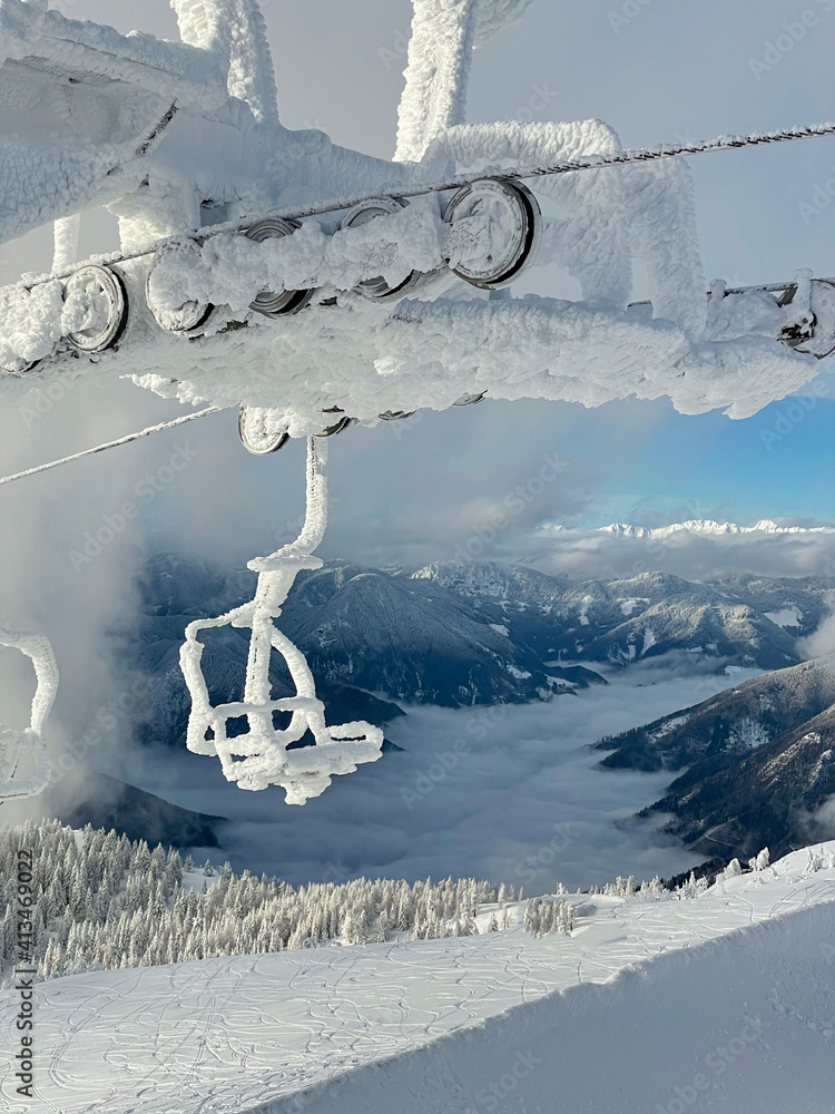垂直：远处雾笼罩的山谷和冰冻的缆车的风景。
