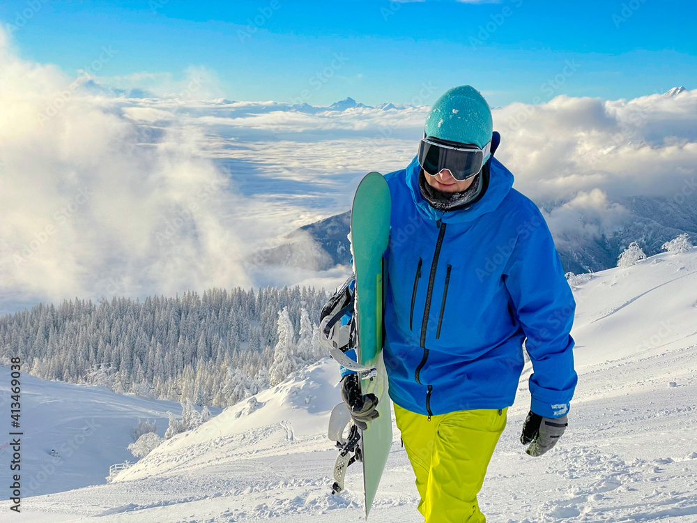 特写：一名兴高采烈的男子带着滑雪板登上了一个封闭的滑雪场斜坡。