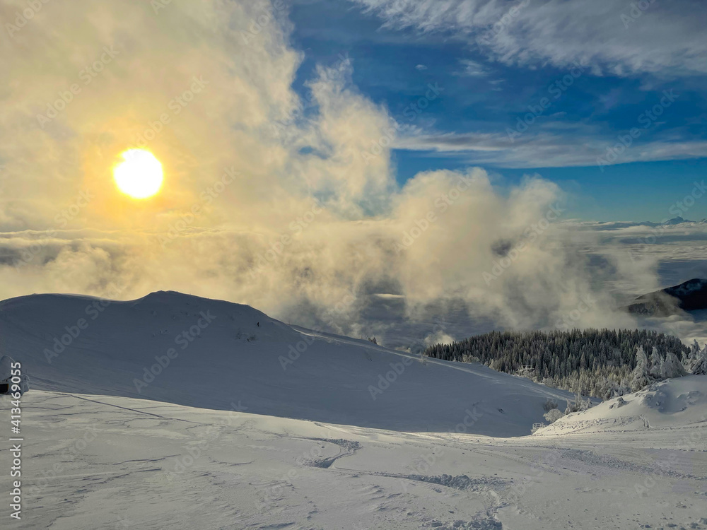 Golden winter morning sun rises above scenic backcountry covered in fresh snow.