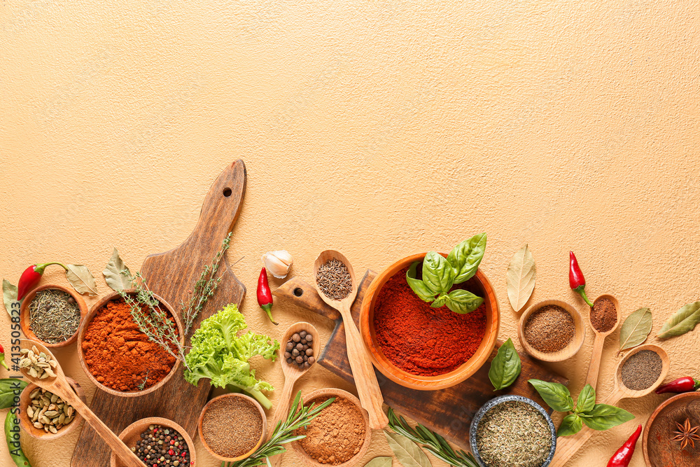 Bowls and spoons with different spices and herbs on color background