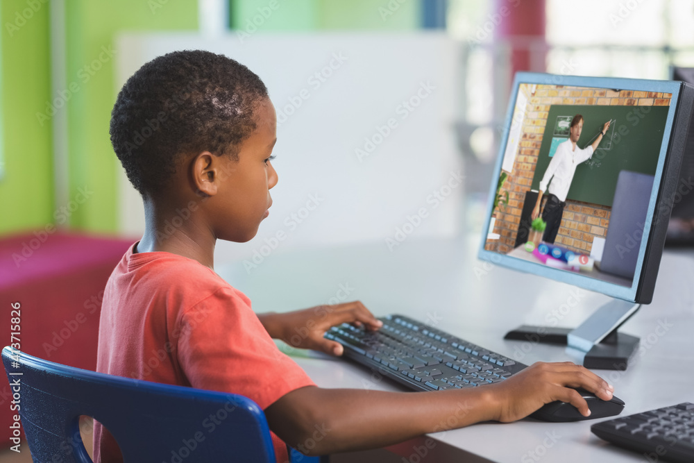 男非裔美国学生在学校与男老师在电脑上进行视频通话