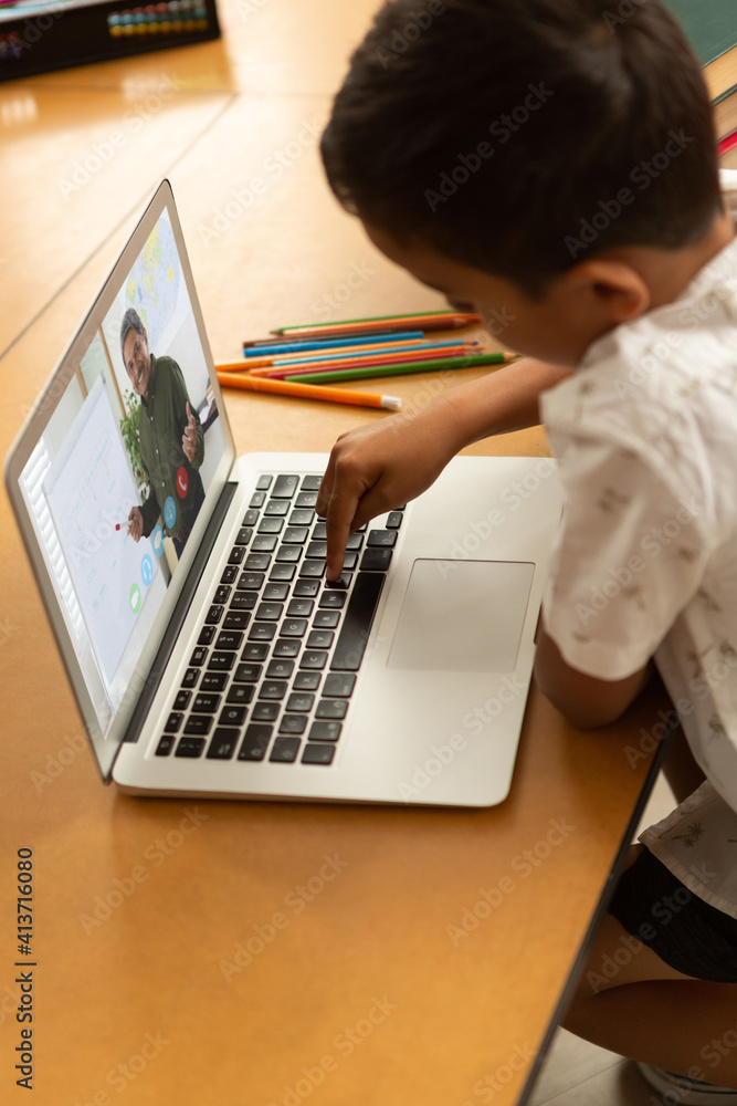 男学生在学校用笔记本电脑与男老师视频通话