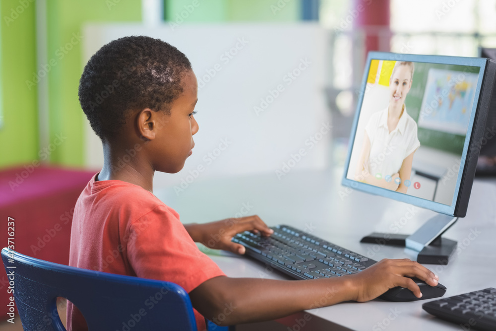 男非裔美国学生在学校与女老师在电脑上进行视频通话