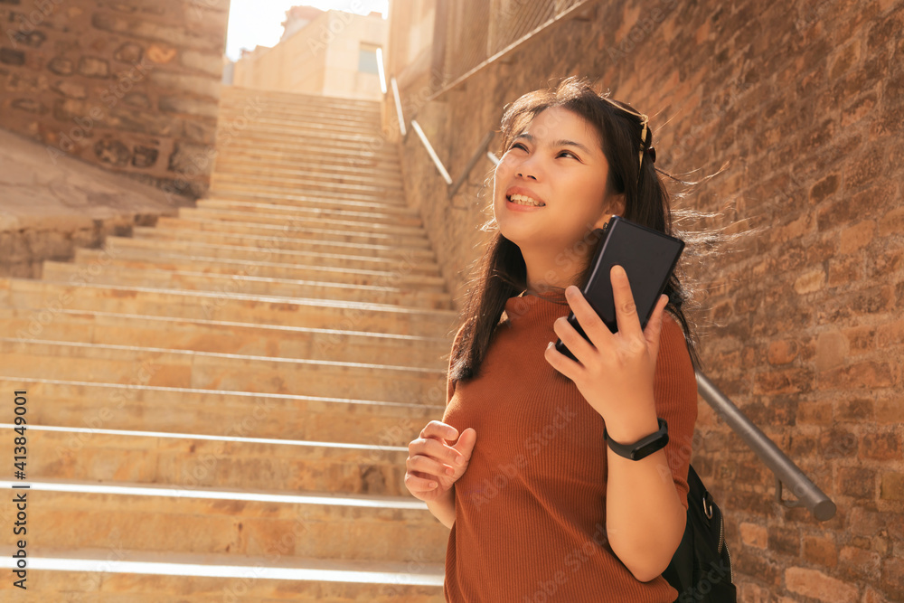 魅力四射的亚洲女性旅行者旅游手用智能手机生活视频通话观光老石头