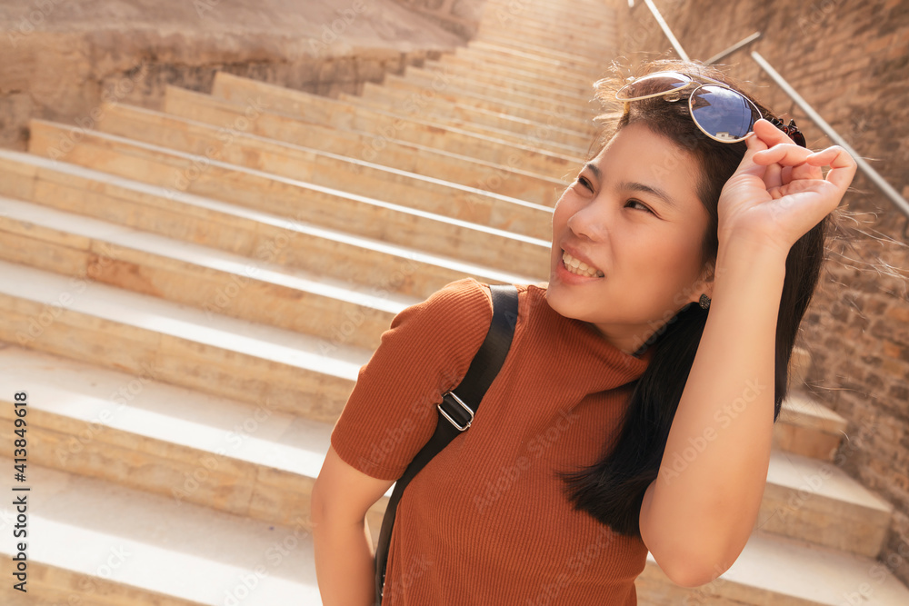 魅力亚洲女性旅行者旅游手摸太阳眼镜欣赏观光老石阶h