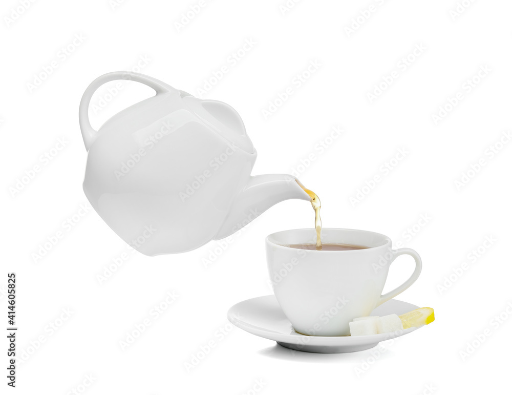 Pouring of hot tea from teapot into cup on white background