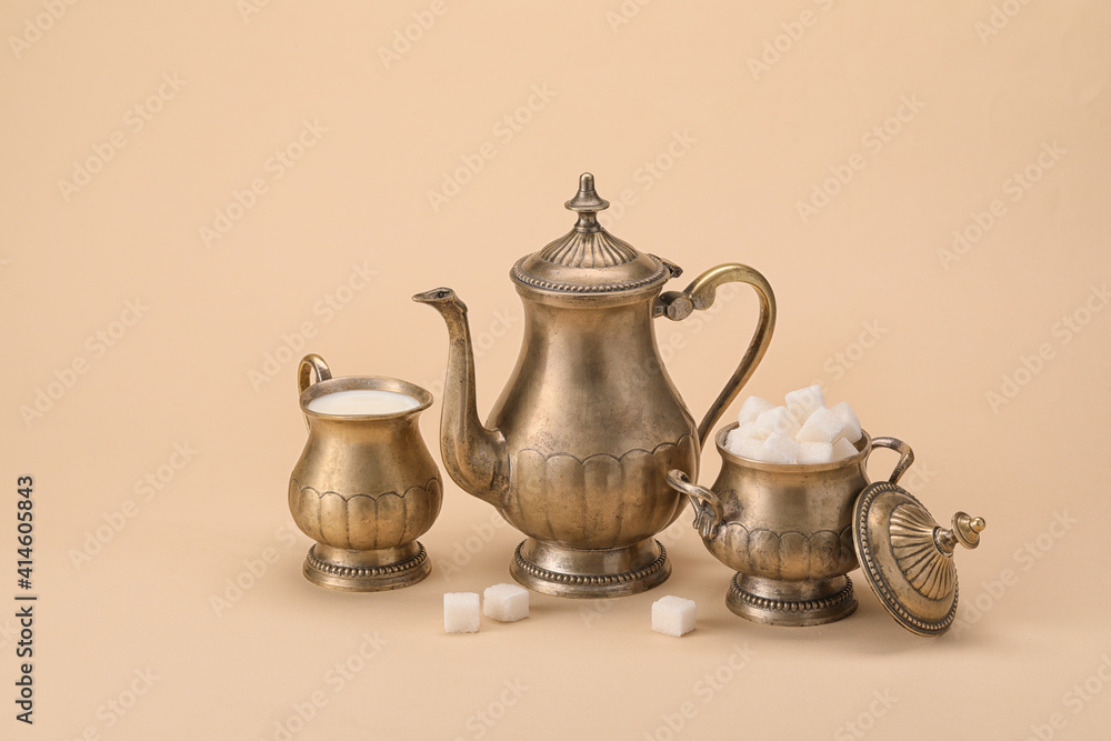 时尚的茶壶，彩色背景上的牛奶和糖