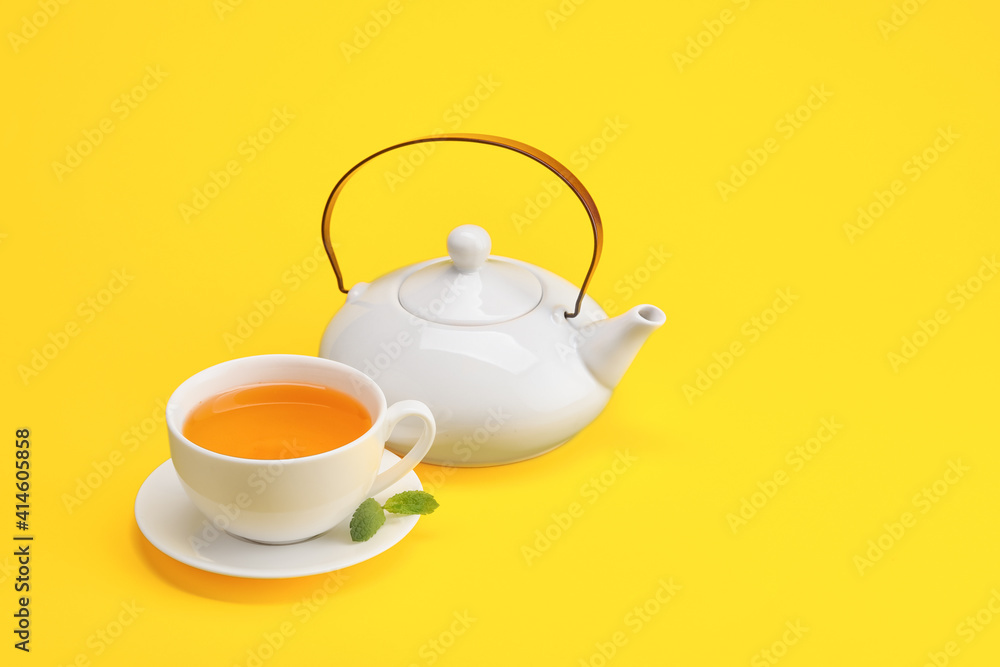彩色背景的时尚茶壶和一杯茶