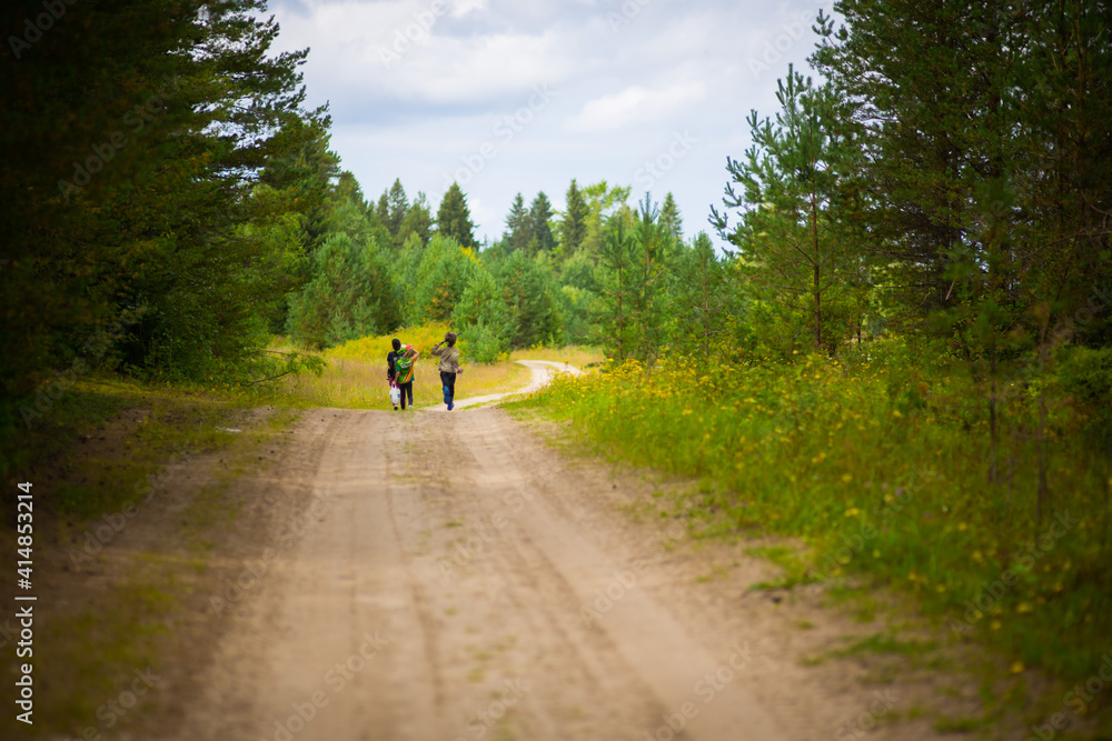 一家人沿着森林道路行走，选择性聚焦
