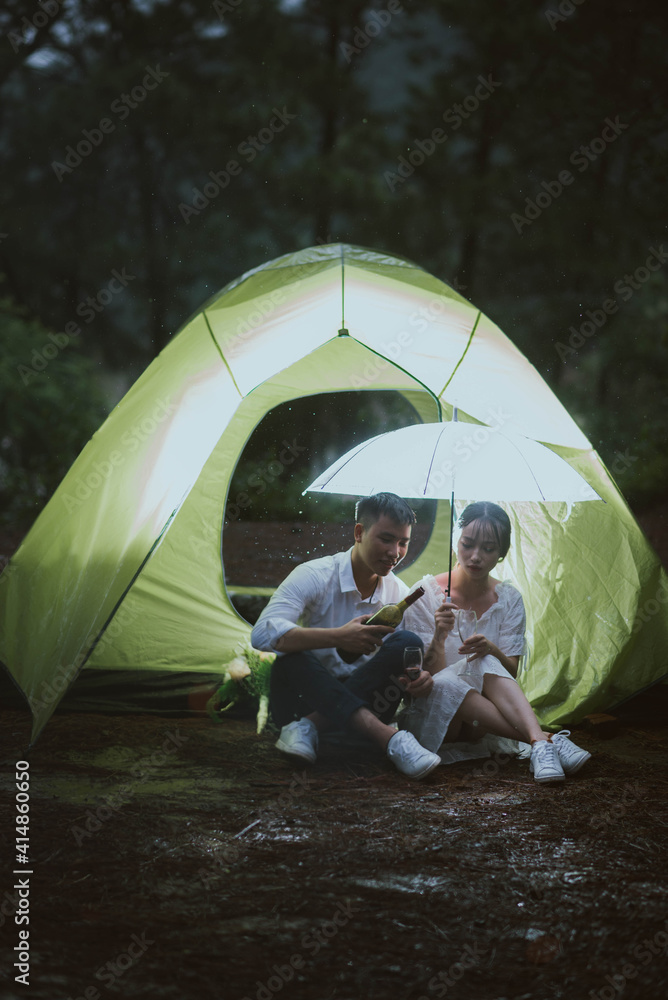 Young Asian couple kissing in the rain
