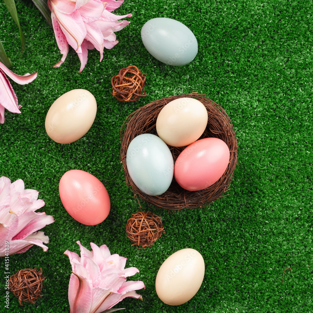 Colorful Easter eggs in the nest on a lawn with pink Double Lily flower.