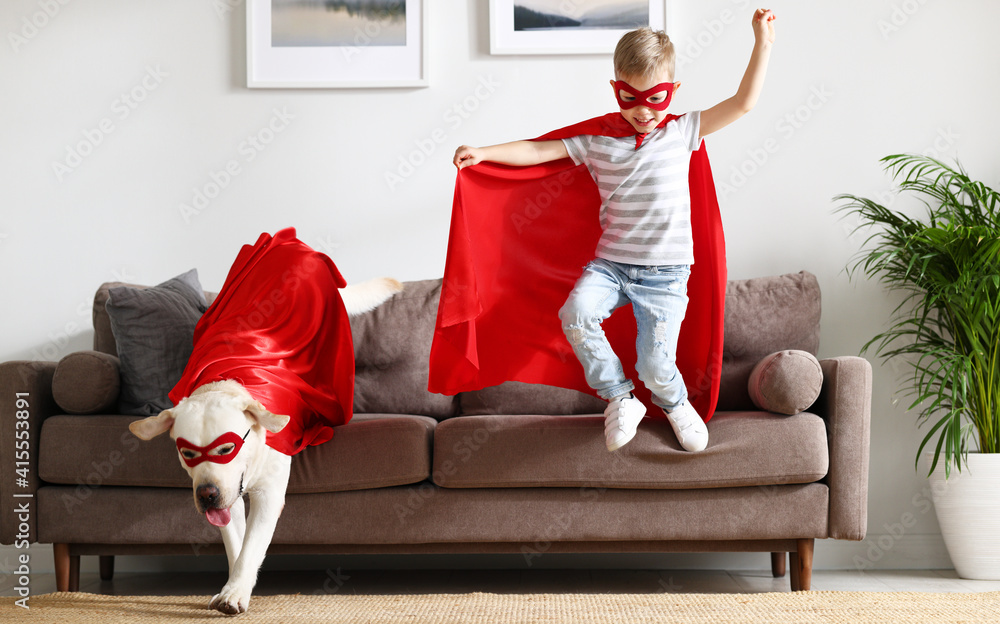 穿着超级英雄服装的快乐孩子和狗在家玩得很开心