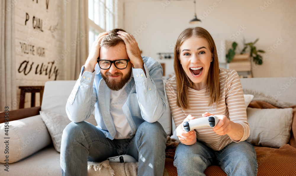 Anxious man watching woman playing videogame