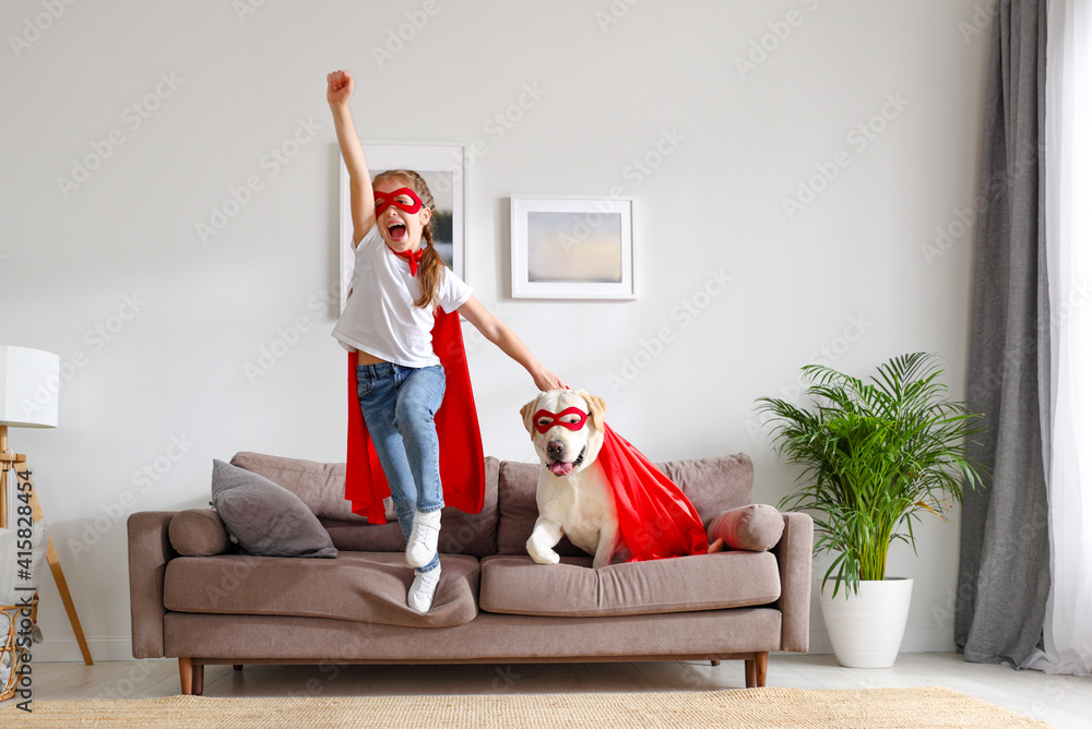 快乐的孩子和穿着超级英雄服装的狗在家玩得很开心