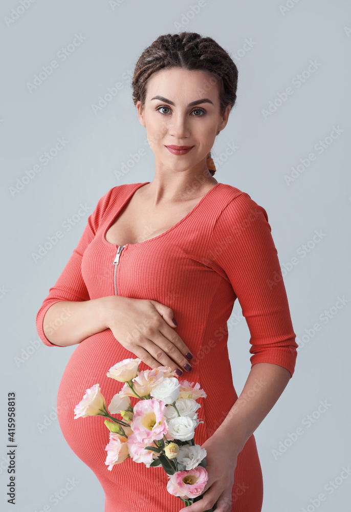 美丽的孕妇，灰色背景上有花