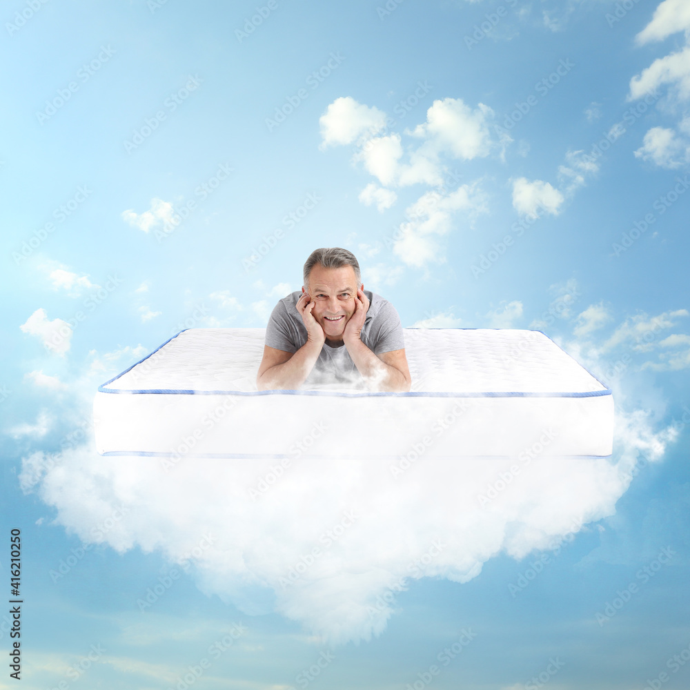 成熟的男人躺在床垫上，柔软如蓝天中的云朵