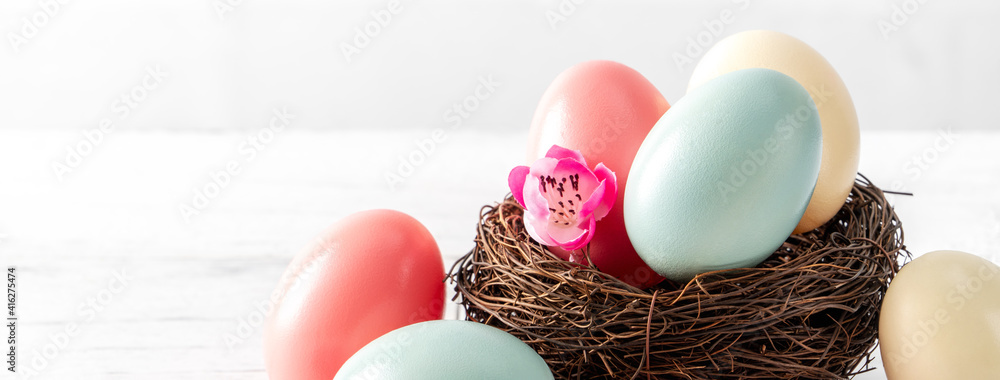 粉红色梅花巢中五颜六色的复活节彩蛋特写。
