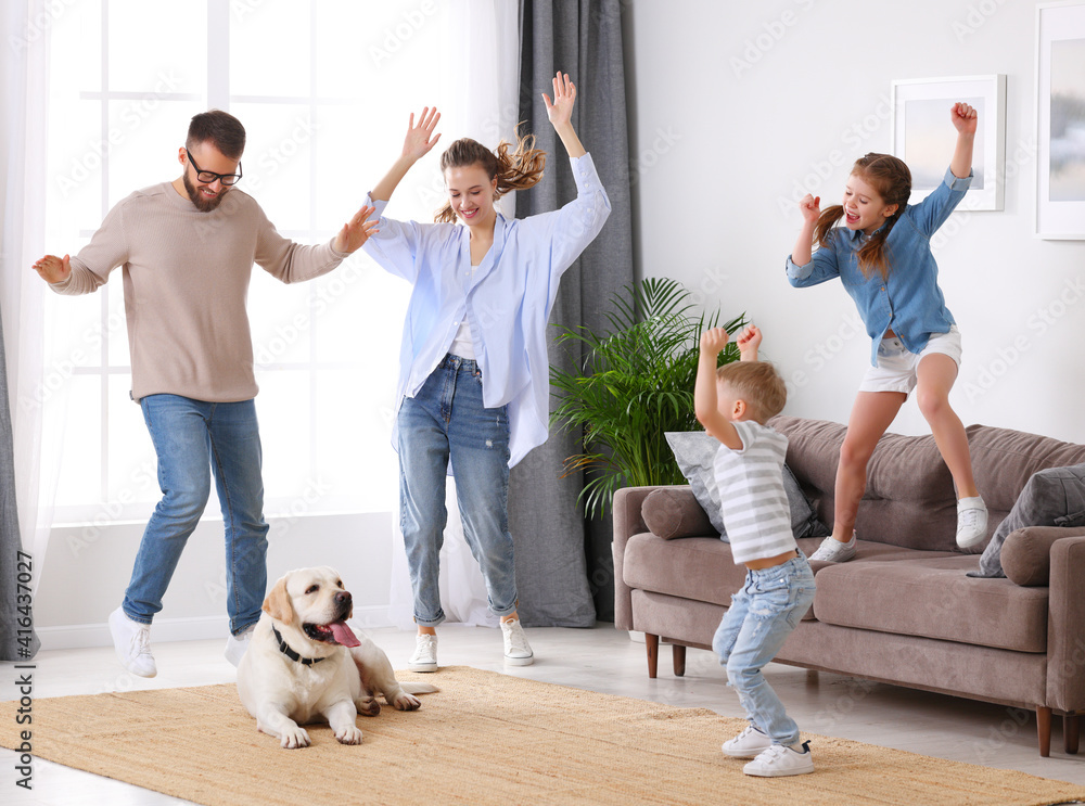 嬉戏的一家人和狗在客厅跳舞