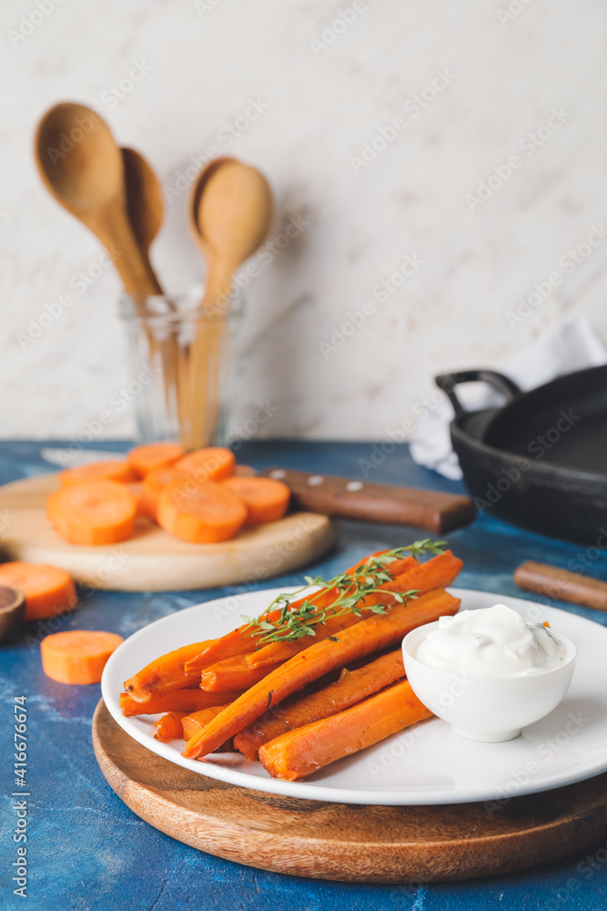 Plate of tasty baked carrot on color background