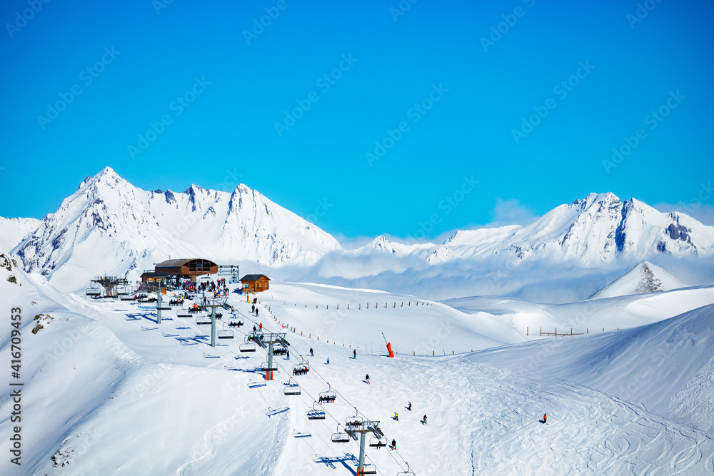 Ski station high in the mountain Les Arcs region of Alps with chairlifts and snow peaks on backgroun