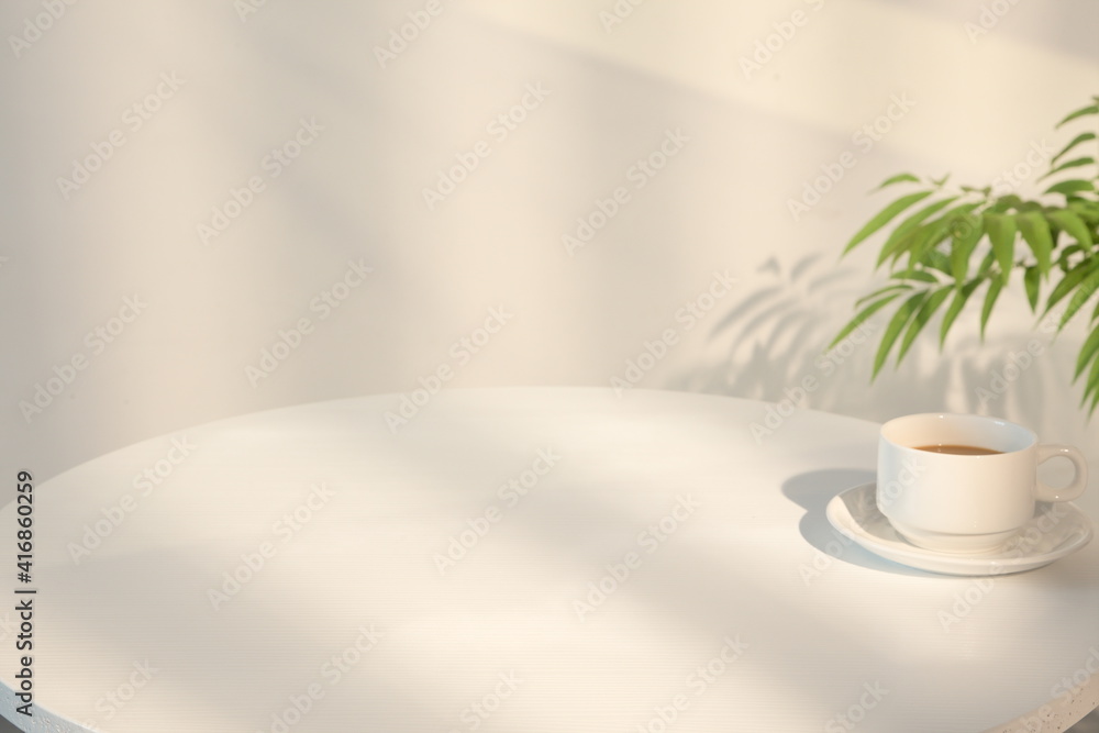 圆形木桌上的白色杯子里的咖啡，米色背景，有复制空间