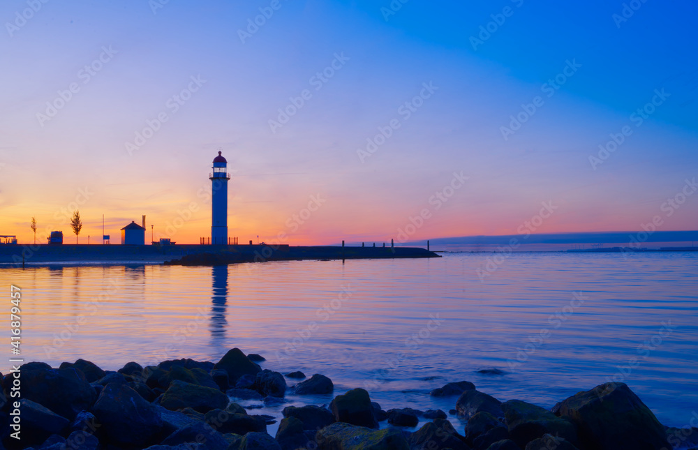 日落背景下海港灯塔的剪影