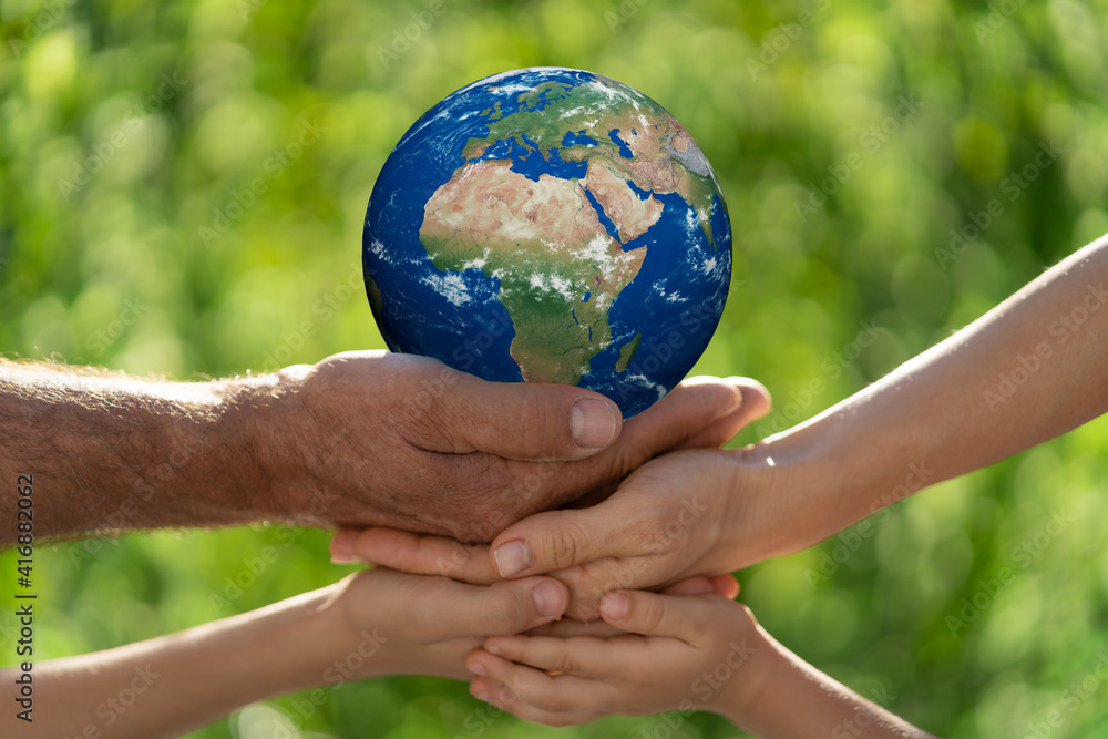 一家人将地球握在手中。这张图片的元素由美国国家航空航天局提供