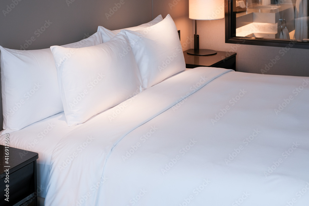 在自然墙壁房间背景上清洁床单和枕头。酒店r的白色床上用品和枕头