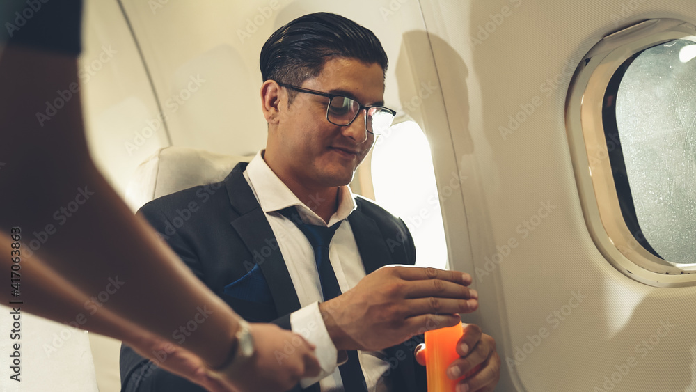 商人在飞机上由空姐提供橙汁。商务旅行的概念。