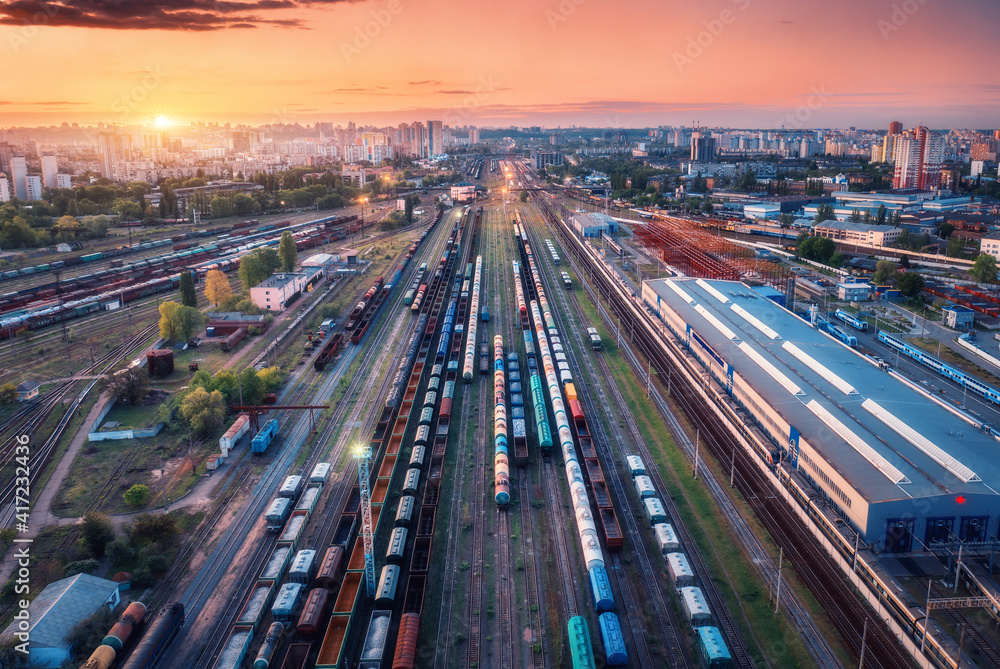 日落时货运列车的鸟瞰图。火车站、货车、铁路的俯视图。重型工业
