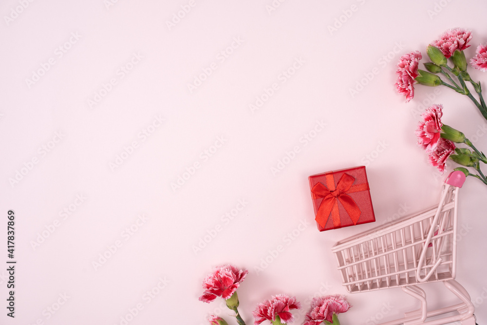 Concept of Mothers day holiday greeting with carnation bouquet on pink background