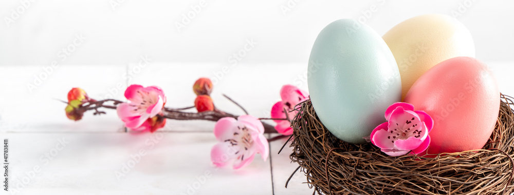 粉红色梅花巢中五颜六色的复活节彩蛋特写。