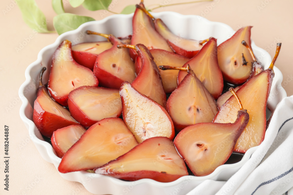 Baking dish with sweet poached pears in red wine on light background, closeup