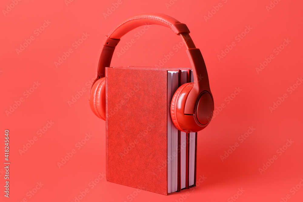 Blank books and headphones on color background