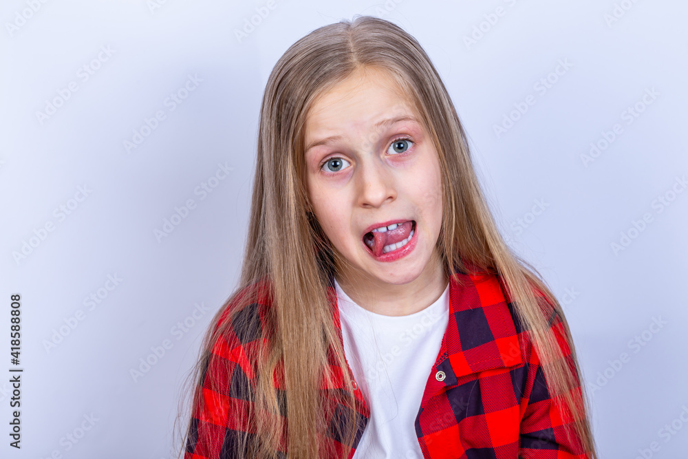 白色头发的女孩露出舌头。白色背景有复制空间。红色格子衬衫。