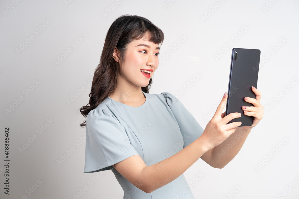 Young Asian woman holding tablet on white background