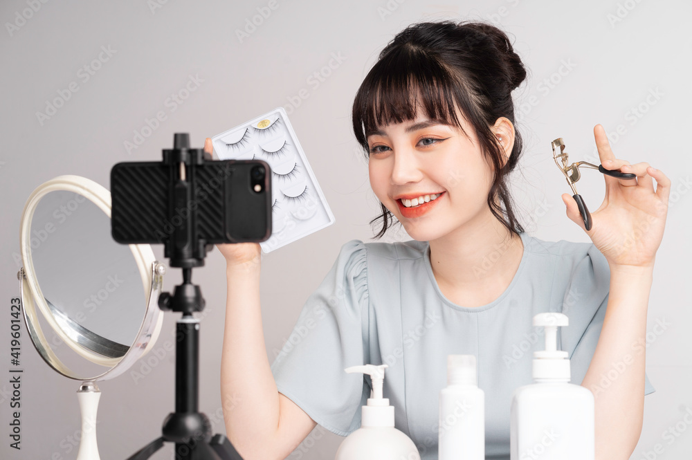 年轻的亚洲女性直播到在线教授化妆