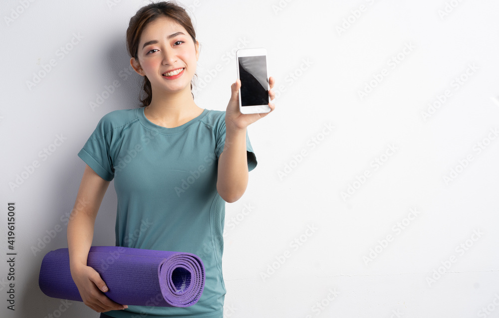 年轻的亚洲女性在白人背景下锻炼
