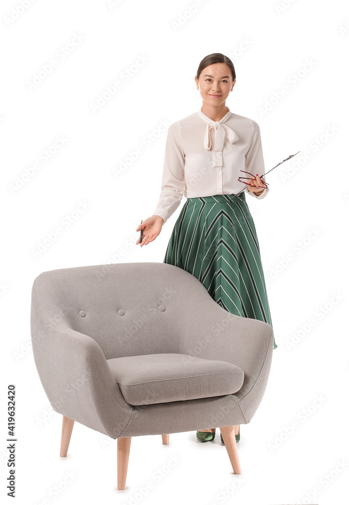 Portrait of female psychologist near armchair on white background