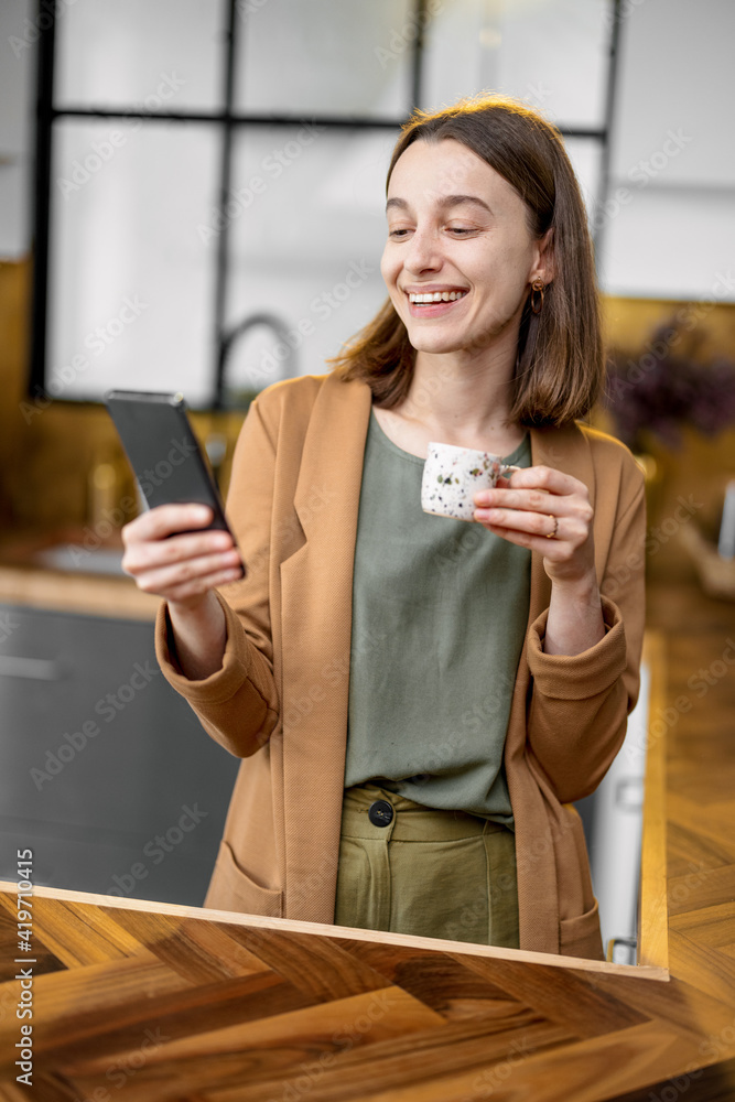 穿着生活服的漂亮女人在上班前打电话喝咖啡