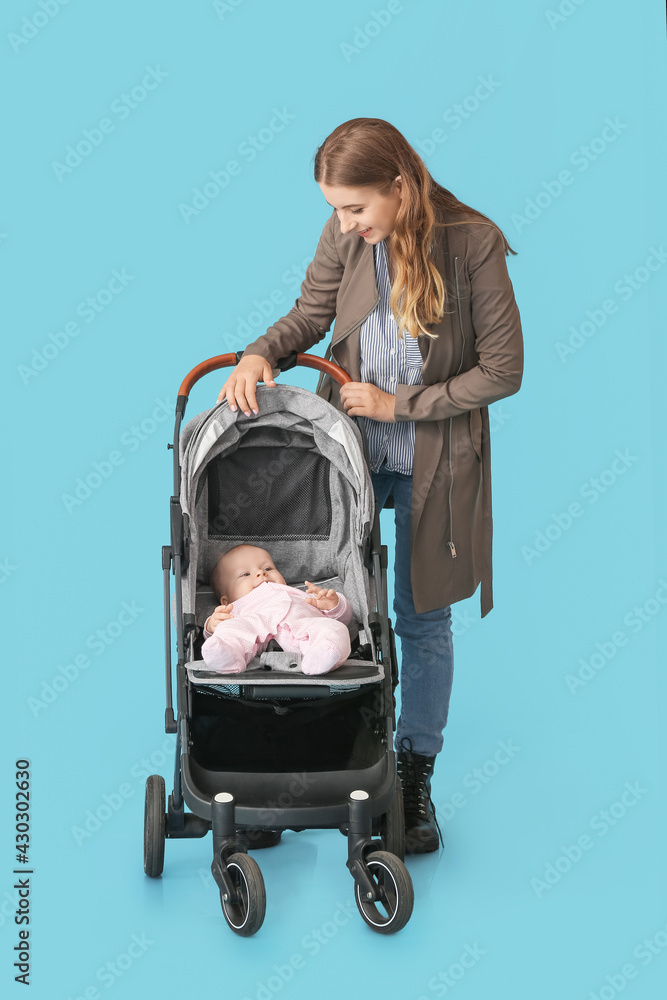 彩色背景的婴儿车里的女人和她可爱的婴儿