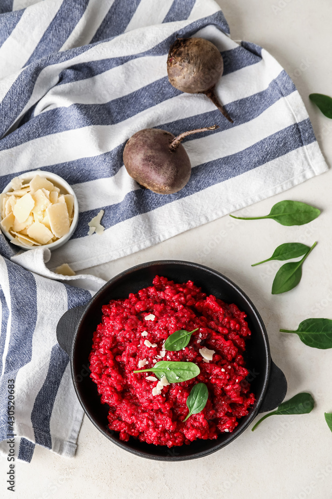 Frying pan with tasty beet risotto on light background