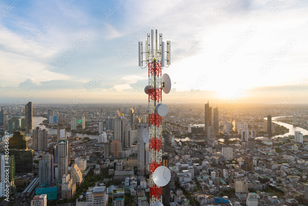 城市日落背景下带5G蜂窝网络天线的电信塔