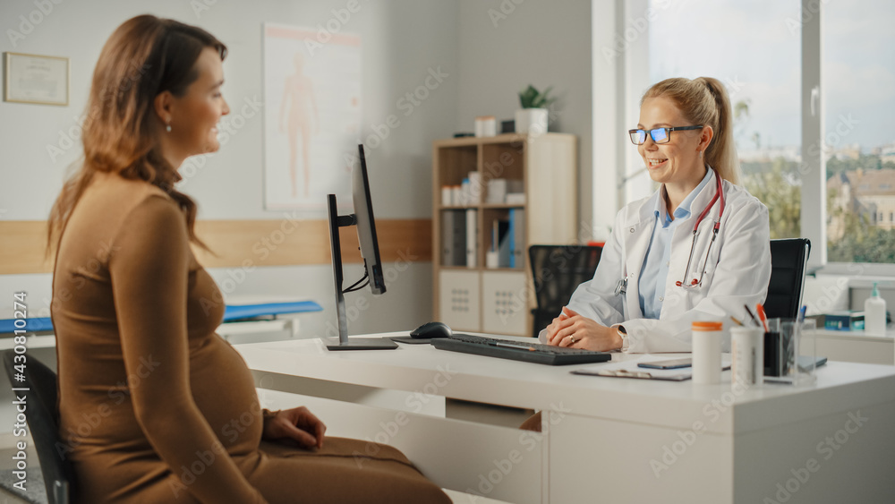 Female Family Doctor is Talking with Young Pregnant Patient During Consultation in a Health Clinic. 