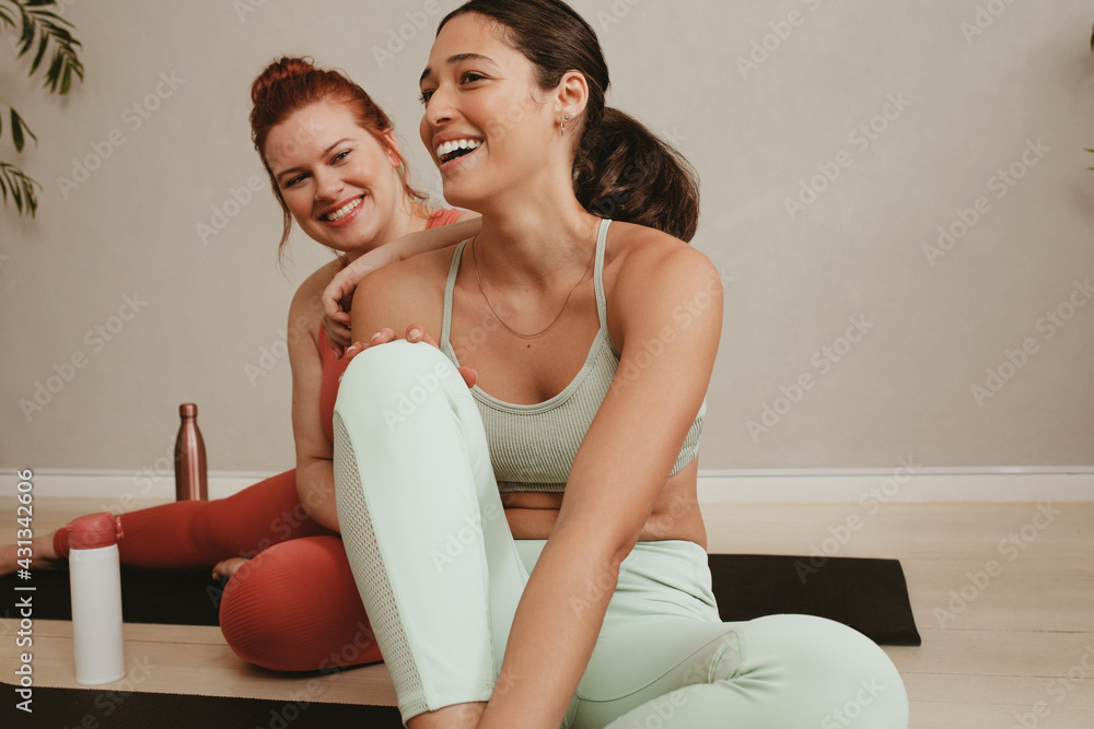 微笑的女性朋友在健身训练后放松